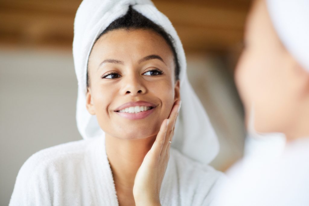 Female admiring clear skin on face in the mirror