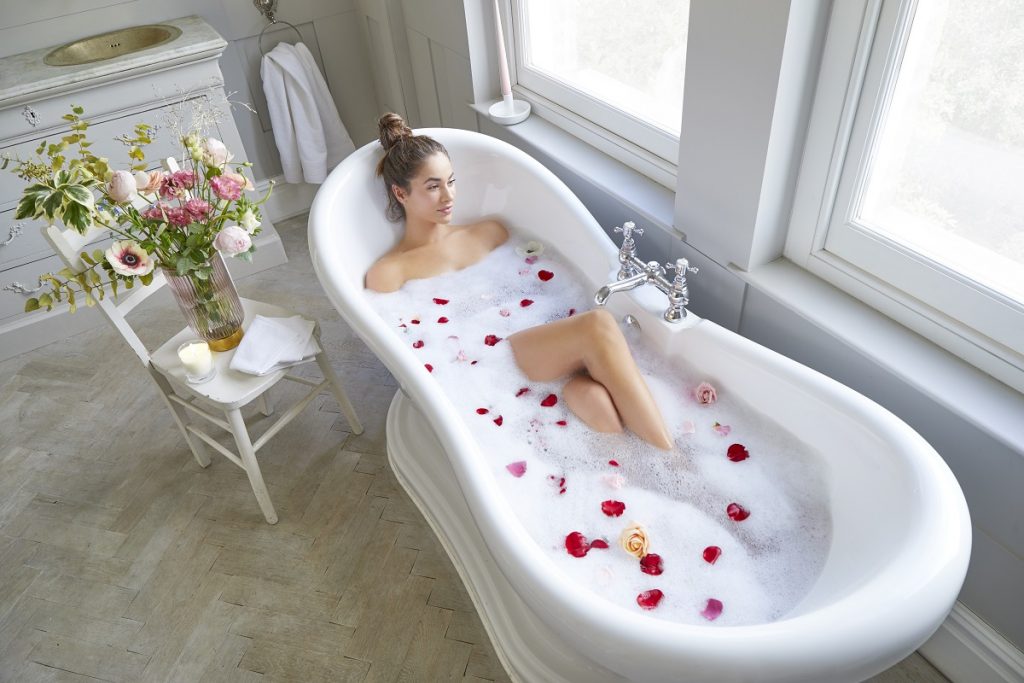 Brunette female in the bath with bubbles and bath oil