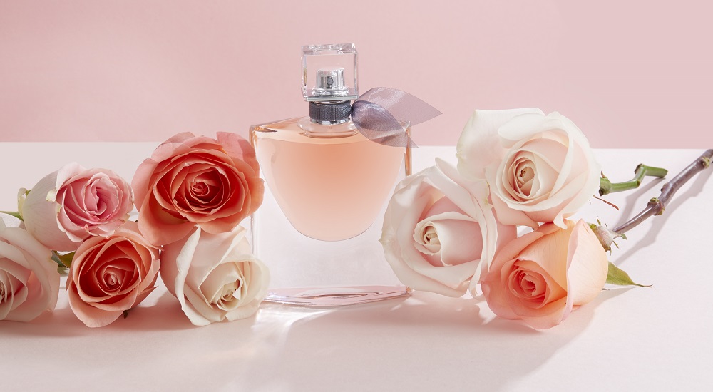 la vie est belle lancome perfume bottle in middle of pink roses