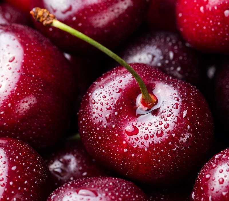 pile of cherries covered in water drops