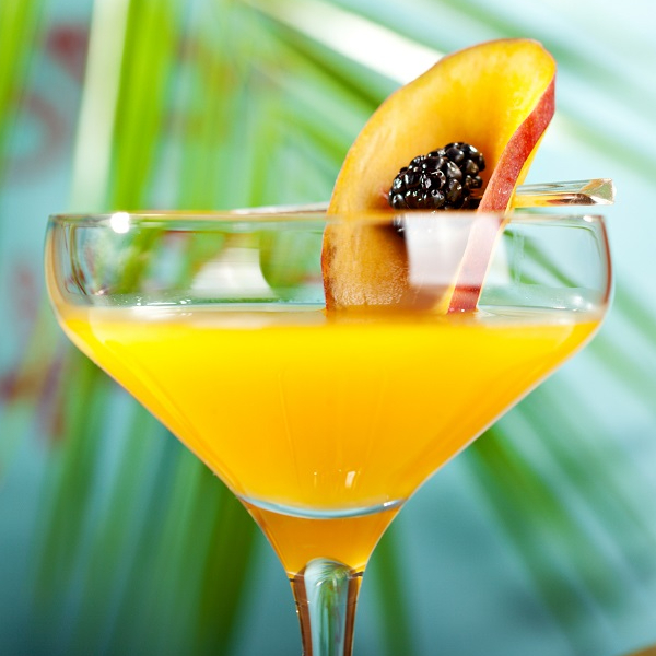 Passionfruit martini cocktail in glass with tropical backdrop