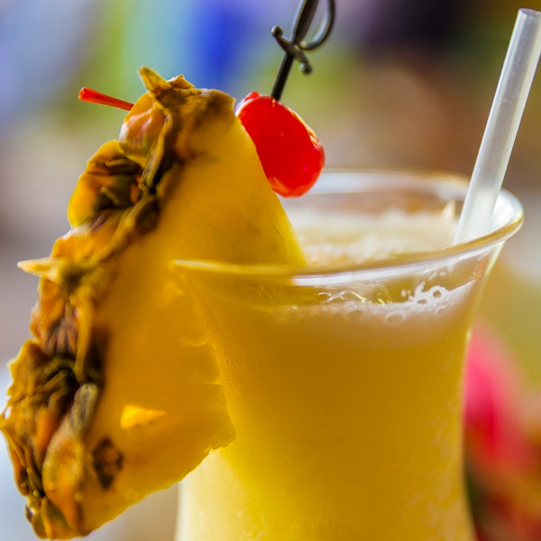 Pina colada cocktail in glass with close up of pineapple slice