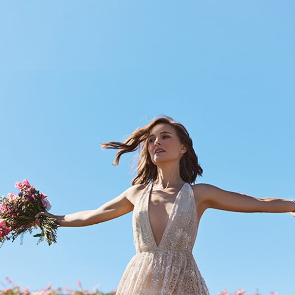 Model standing in field of flowers