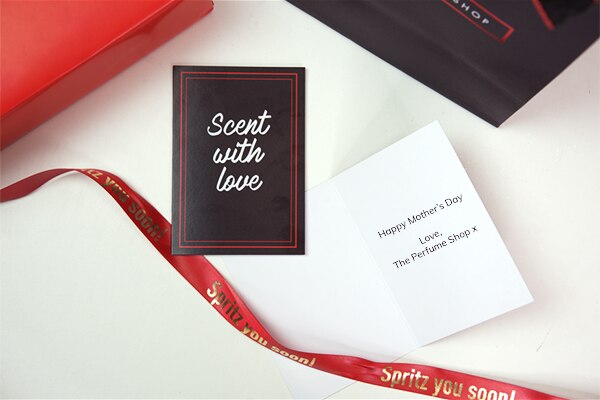 A member of staff gift wrapping perfume