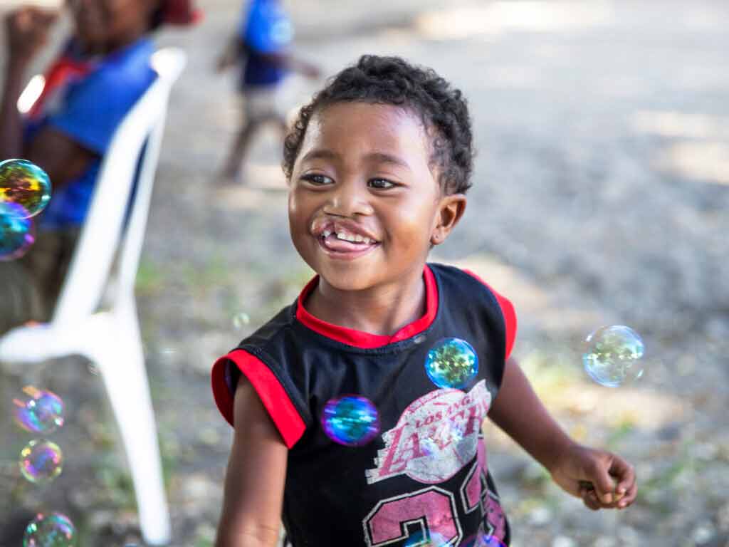 A child smiling with a broken smile