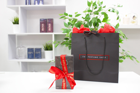 Gift ribbons around perfume and a gift bag