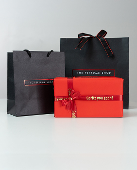 The Perfume Shop gift bag, and ribbons wrapping a present.