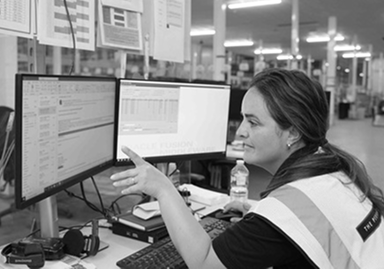 A lady in a warehouse looking at a computer screen