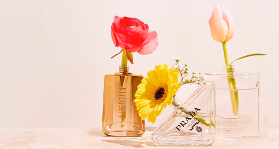 3 perfume bottles that are being used as a vase with a flower inside