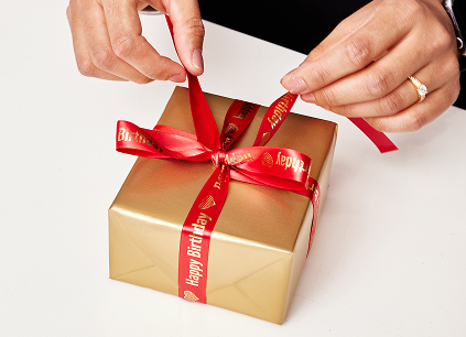 A gold gift with a red ribbon