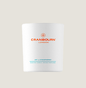 A white candle with orange writing