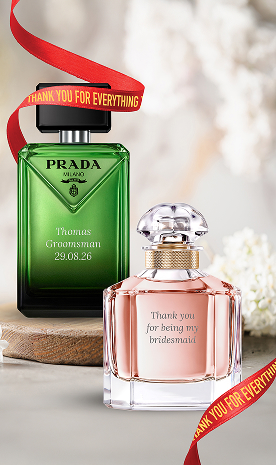 A bottle of Prada Paradigme and Mon Guerlain, both engraved with red personalised ribbons around them